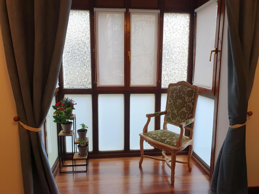 una camera con una sedia e una finestra di Erkiaga Etxea a Lekeitio