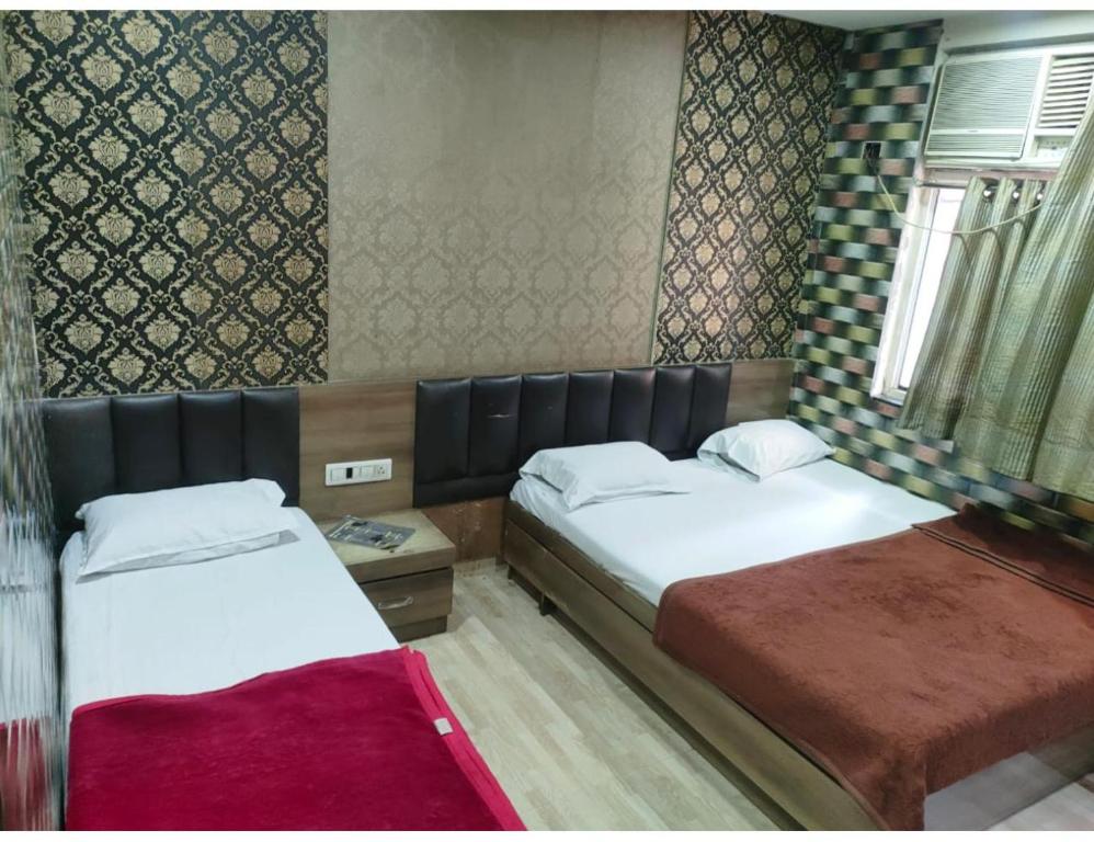 een kamer met 2 bedden en een raam bij Hotel prince palace & restaurant , Ajmer in Ajmer
