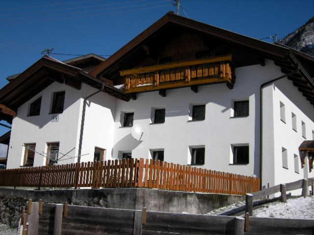 ein weißes Haus mit einem Holzzaun davor in der Unterkunft Prantl Roswitha in Sölden