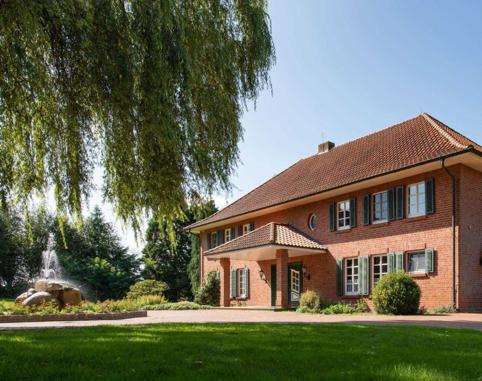 een stenen huis met een fontein in de tuin bij Herrenhaus im Artland in Ankum