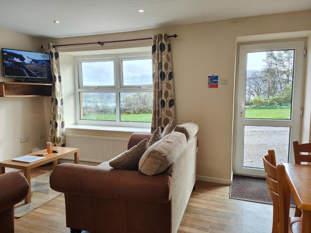 a living room with a couch and a window at Holiday Cottage 4 in Penrith