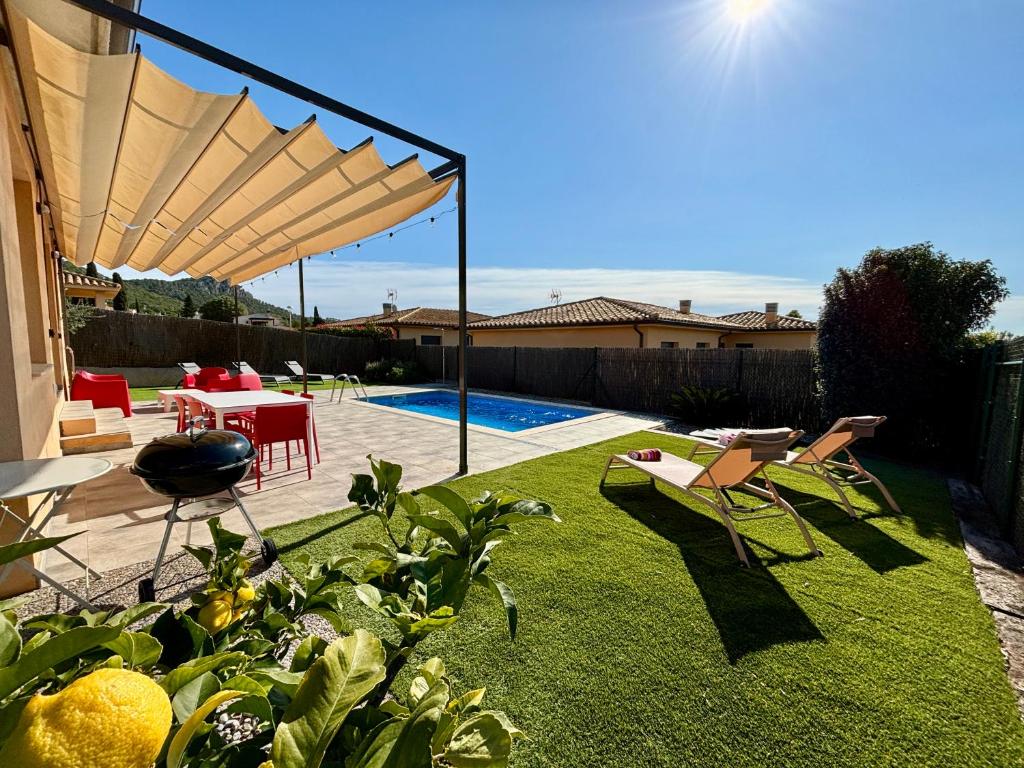 een tuin met een patio met een tafel en stoelen bij Villas Medes Mar - Plus Costa Brava in L'Estartit