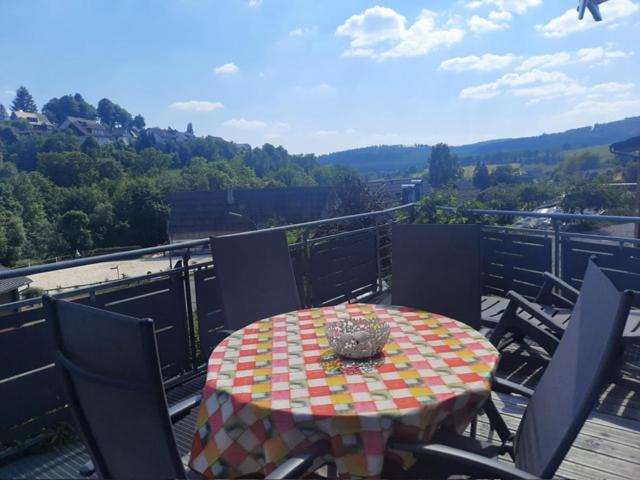 a table and chairs on a balcony with a view at Artgerecht Naturverliebt in Bad Berleburg