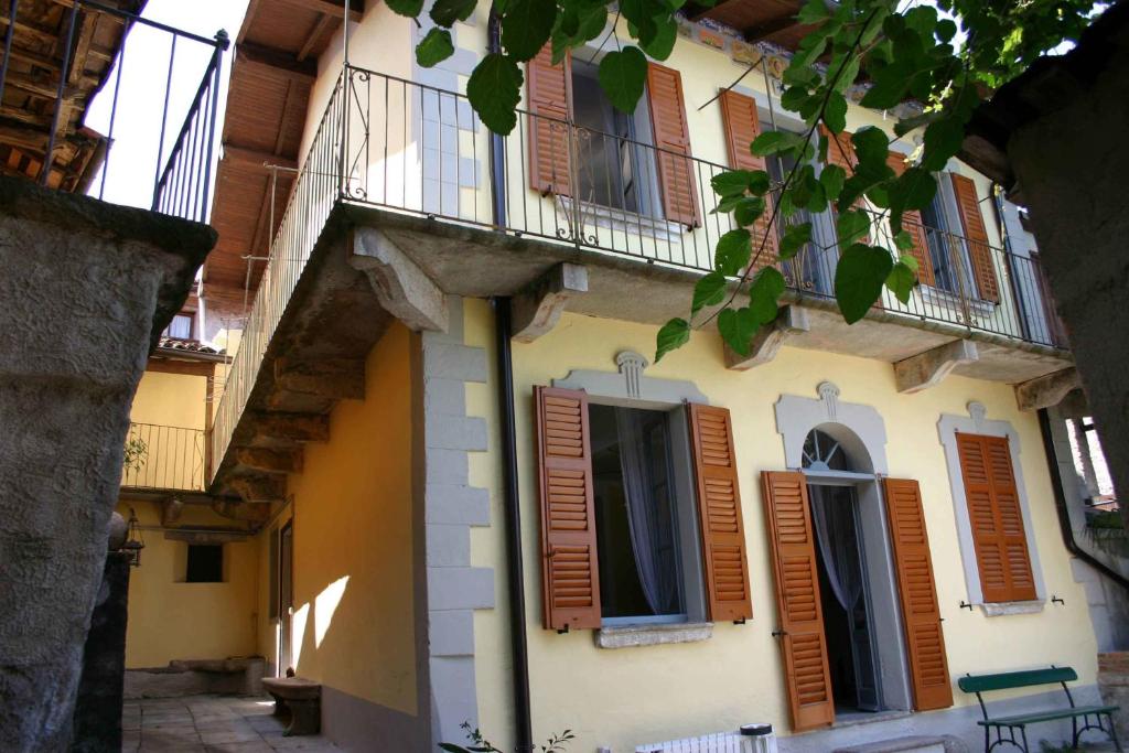 ストレーザにあるLa Ca' Vegiaの茶色のシャッターとバルコニー付きの建物