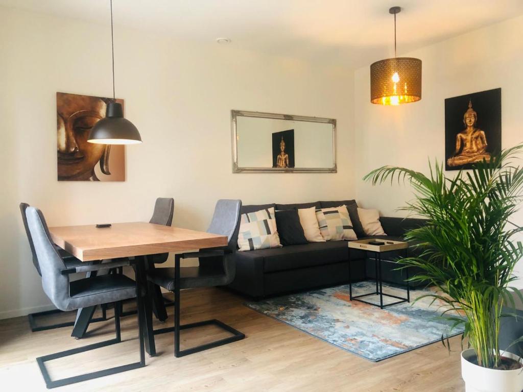 a living room with a table and a couch at City Zen Apartment Enschede !Free Private Parking in Enschede