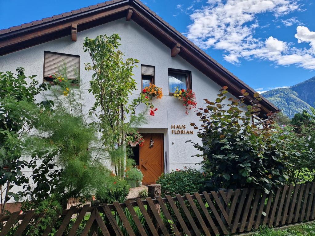 una casa con flores en las ventanas y una valla en Apart Haus Florian en Imst