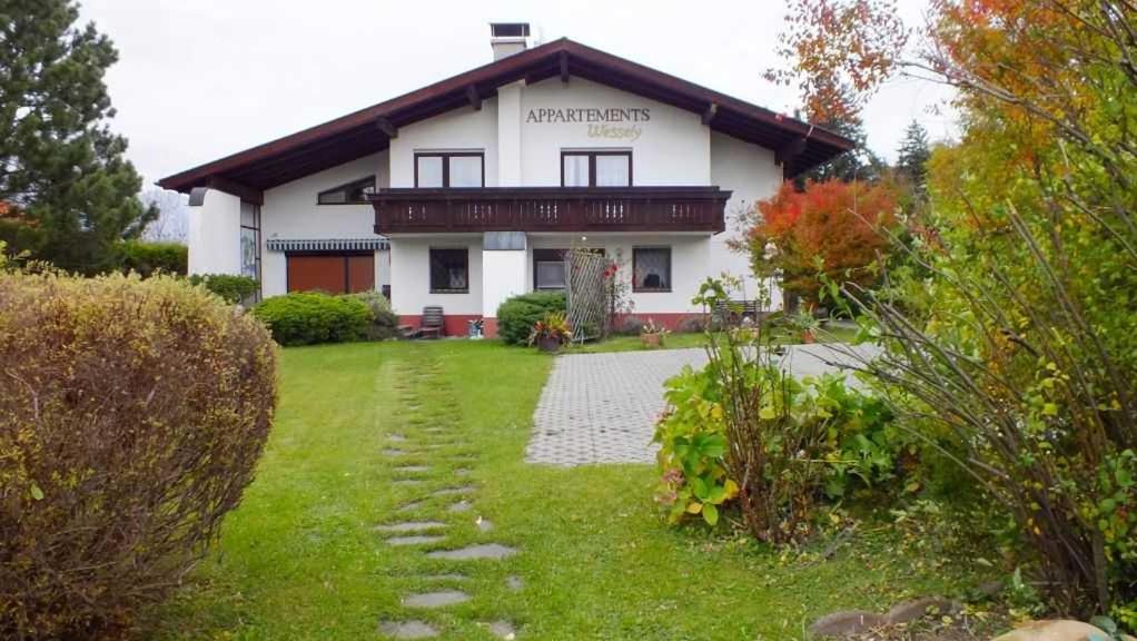 ein großes weißes Haus mit einem Garten davor in der Unterkunft Appartements Wessely am Golfplatz Lans Innsbruck in Innsbruck