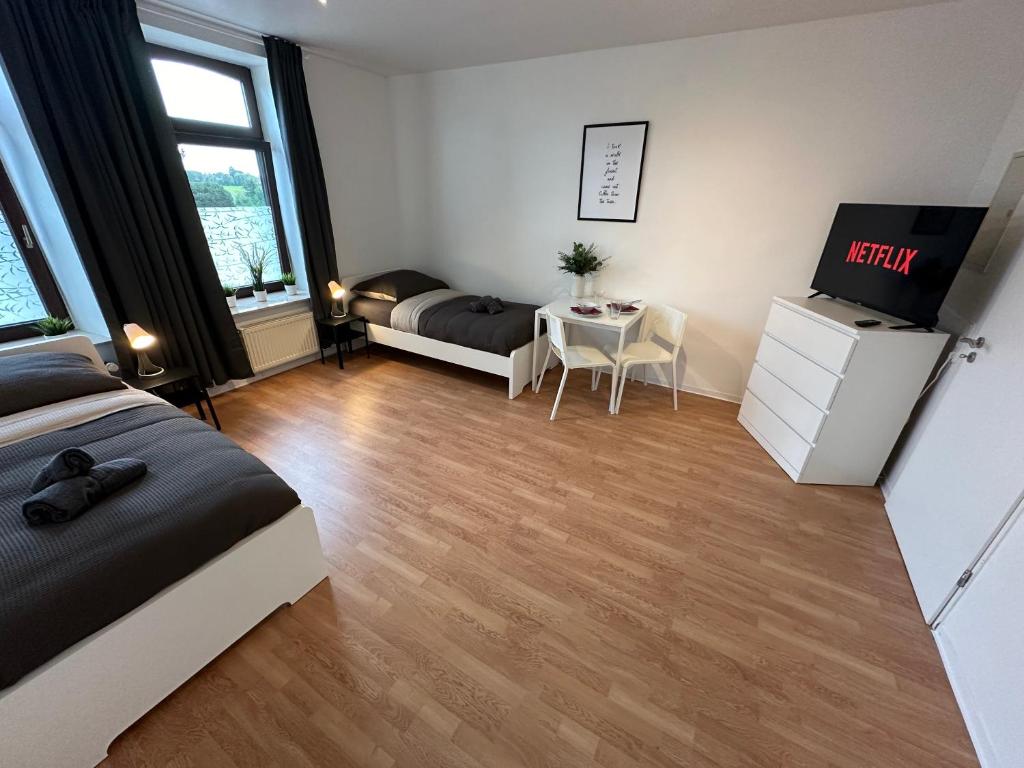 a bedroom with a bed and a table with a tv at Premium Unterkunft für Monteure und Geschäftsreisende : Vollausgestattet, WIFI & Washing in Lembruch