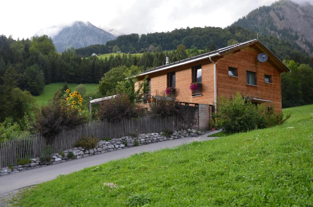 una casa en una colina con una valla en Ferienwohnung Freiraum, en Dalaas