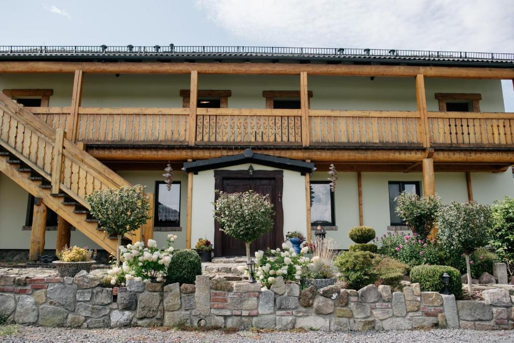 Una casa grande con una terraza de madera en la parte superior. en Agroturystyka Natura, en Pilchowice