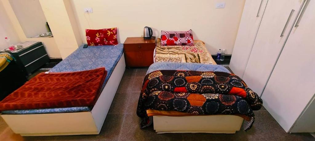 Kleines Zimmer mit 2 Betten und einem Schreibtisch. in der Unterkunft VB dormitory in Neu-Delhi