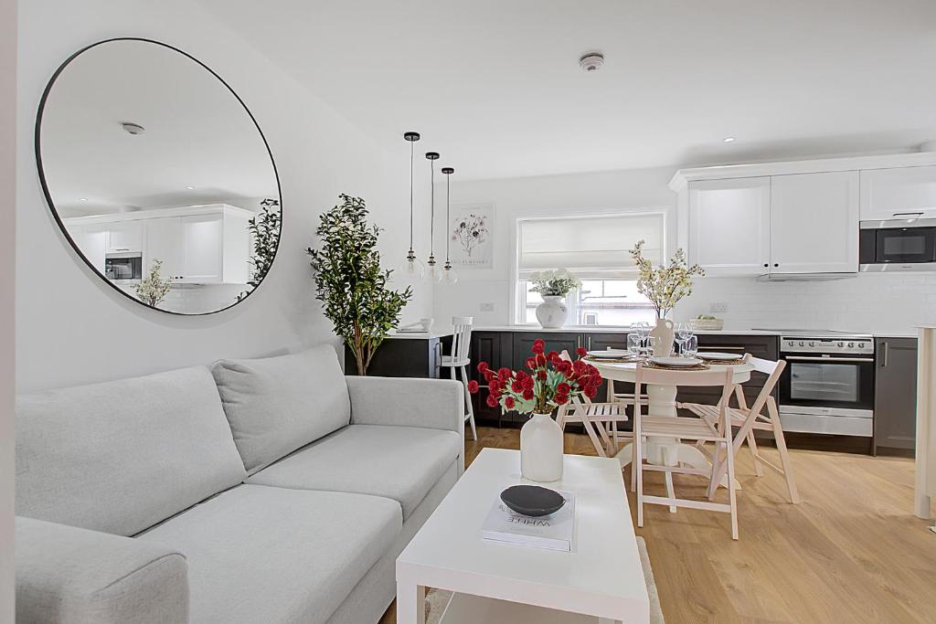 uma sala de estar branca com um sofá e uma mesa em Quality Apartments Close to Tube em Hendon