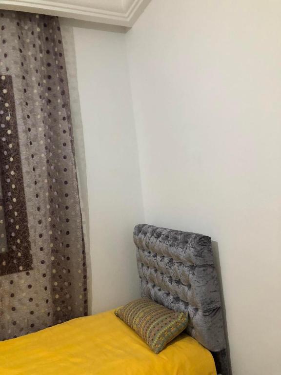 - une chambre avec un lit jaune et un rideau dans l'établissement Une belle maison à houmet souk, à Houmt Souk
