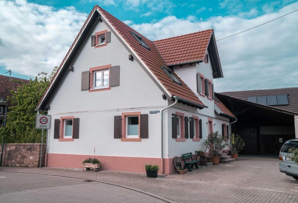 uma casa branca com um telhado vermelho em SCHULTE Appartements & MEHR em Meißenheim
