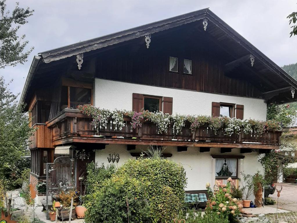 ein Haus mit einem Balkon mit Blumen darauf in der Unterkunft Ferienwohnungen im Griachalgarten - Chiemgau Karte in Inzell