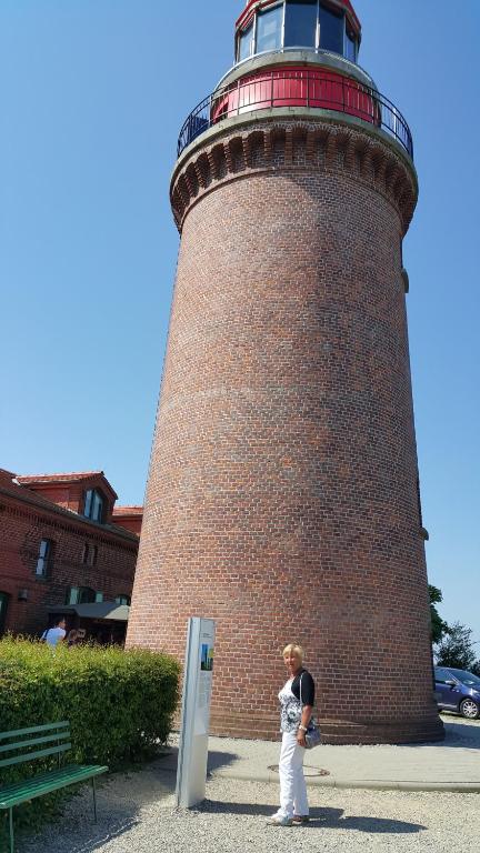 a woman standing in front of a lighthouse at Ferienwohnung und Ferienzimmer in Neubukow
