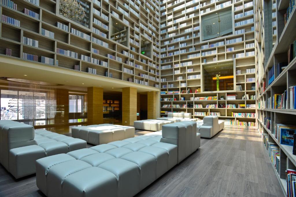 a library with white couches and bookshelves at The Gaia Hotel - Taipei in Taipei