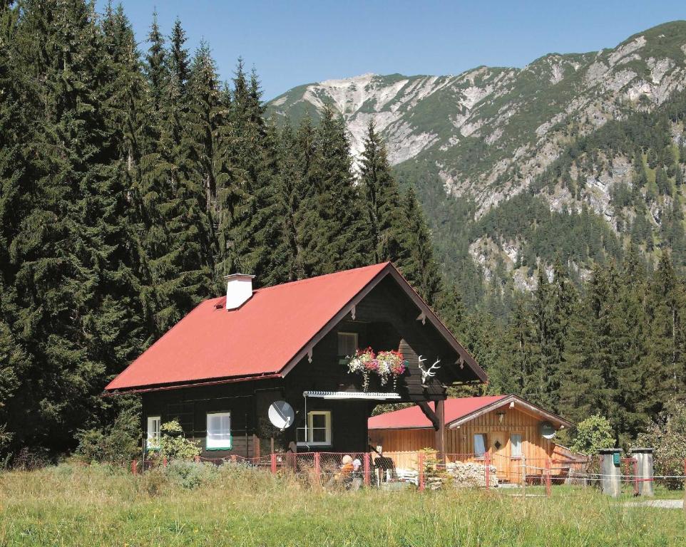 een huis met een rood dak met bloemen erop bij Chalets Grossmitt in Pertisau