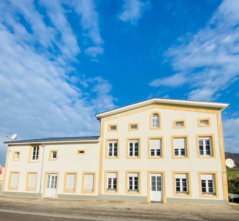 a large white building with a blue sky in the background at Maison de malbrouck in Merschweiller