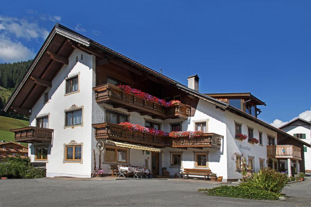 a large white building with flowers on the balconies at Rimmlhof & Rimmlstube in Berwang