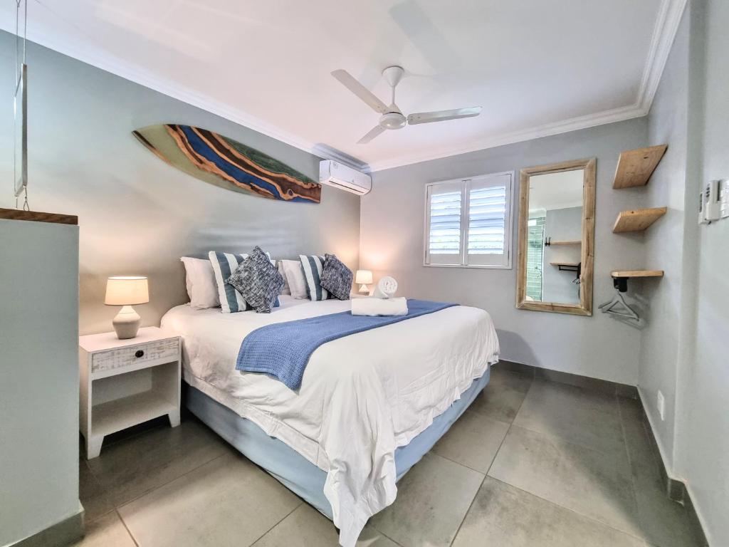a bedroom with a bed and a desk and a mirror at 77 Chaka's Cove in Ballito