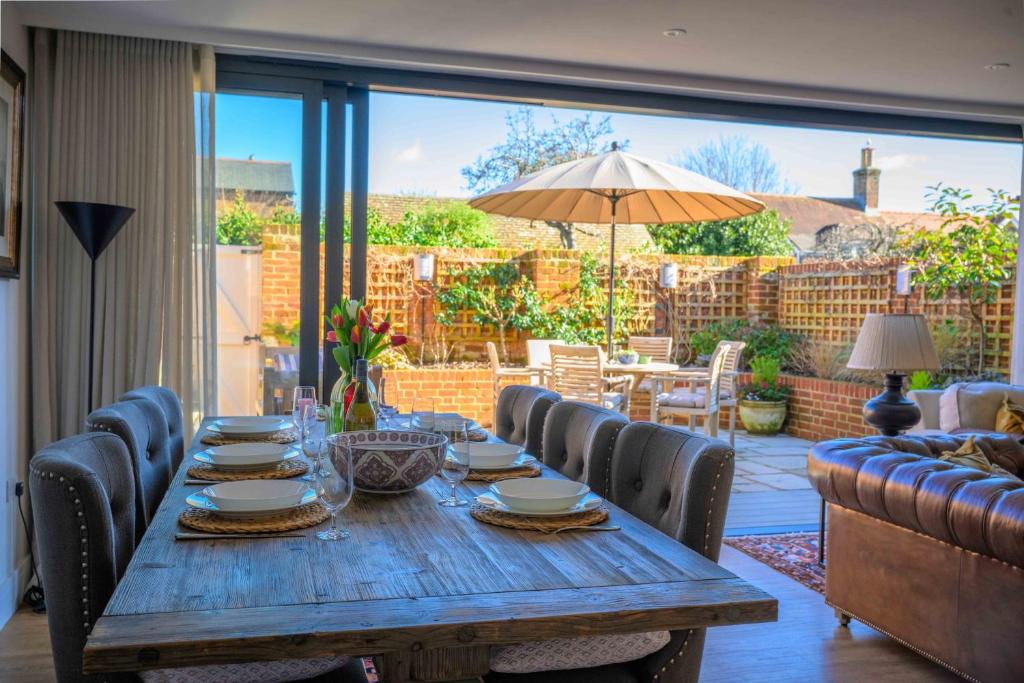 a wooden table with chairs and an umbrella on a patio at Seabiscuit in Lymington