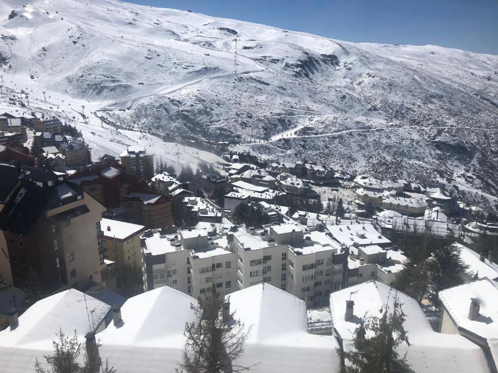 a city covered in snow in front of a mountain at DUPLEX ALCAZABA con parking gratuito, 2 dormitorios , 5pax in Sierra Nevada