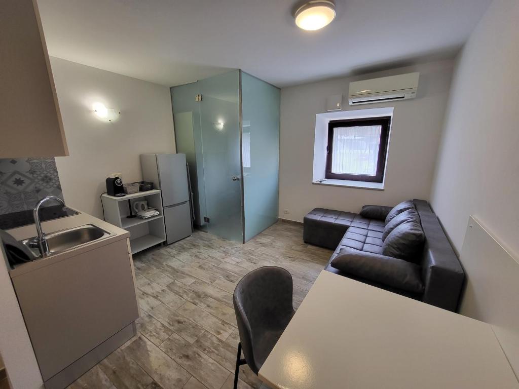 a small living room with a couch and a kitchen at Studio Morsal in Koper