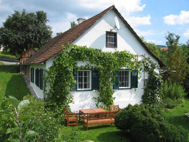 Biały dom z ławką przed nim w obiekcie Beim Schachnerhaus - Urlaub so wie ich ihn mag! w mieście Pöllauberg