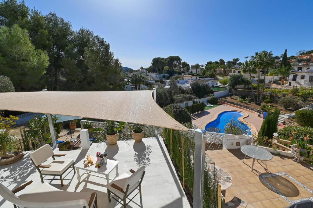 - une terrasse avec un parasol et des chaises aigle ainsi qu'une piscine dans l'établissement Casa Basta, à Moraira