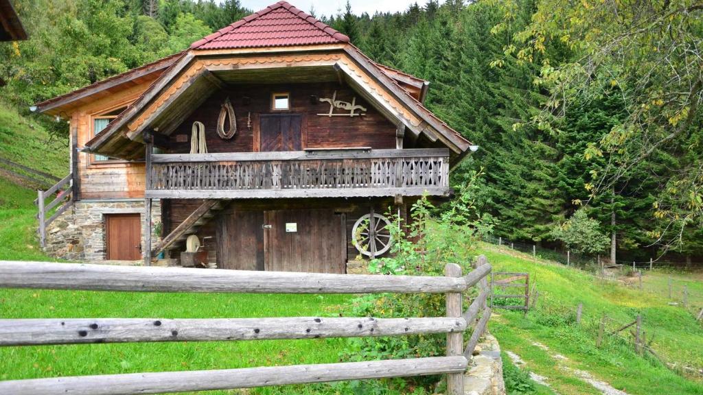 una casa de madera con una valla en un campo en Feldkasten Biohof Lurger, en Breitenbrunn