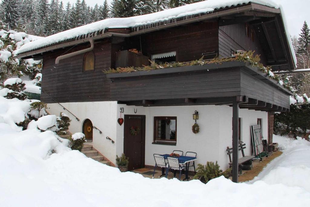 uma casa na neve com uma mesa em Ferienhaus Pasterk em Verditz