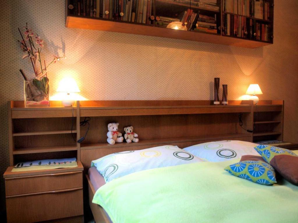 een slaapkamer met een bed met twee knuffels erop bij Ferienwohnung Angelika in Bad Schallerbach