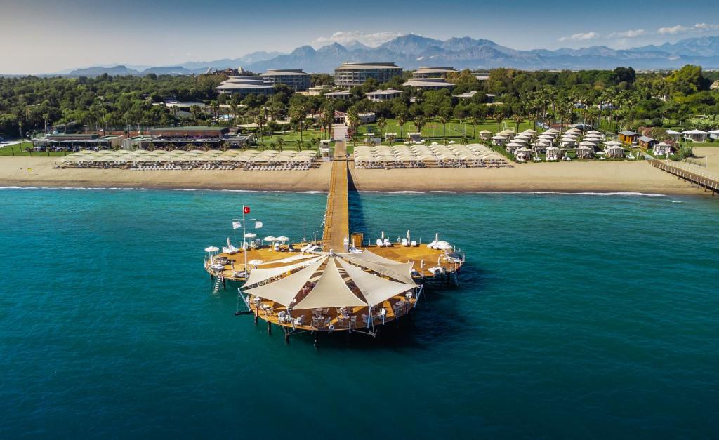 a large boat in the water next to a beach at Calista Luxury Resort in Belek