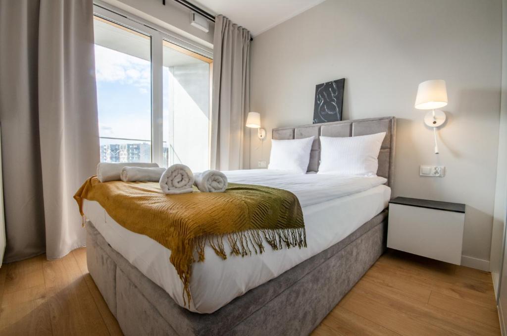 ein Schlafzimmer mit einem großen Bett und einem großen Fenster in der Unterkunft InPoint Tauron Arena Apartment with Parking - Lema 17 in Krakau