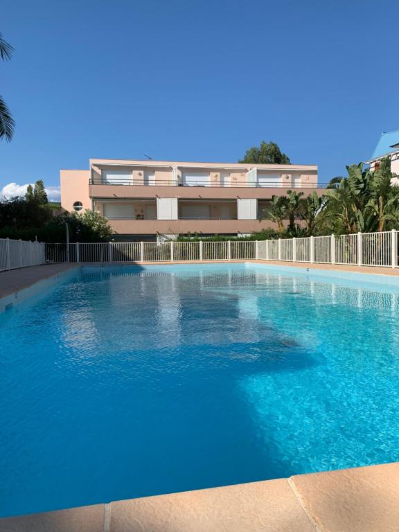 une grande piscine bleue devant un immeuble dans l'établissement appartement résidence riviera avec piscine, au Lavandou