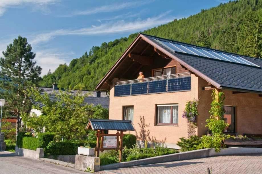 a person sitting on the roof of a house with solar panels at Ferienwohnungen Sigrid & Ferdinand BERGINC in Hohenlehen