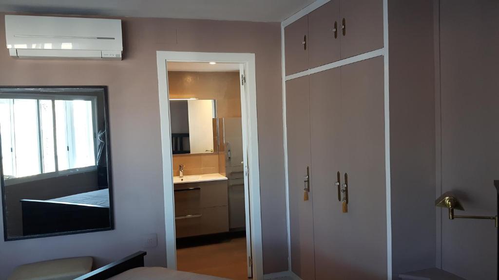 a room with a door with a mirror and a kitchen at bello-horizonte Salou playa in Salou