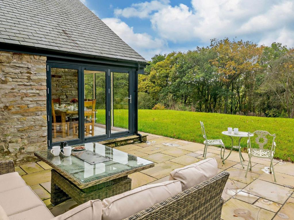 a conservatory with a table and chairs on a patio at 3 Bed in Brecon 93680 in Llandefalle