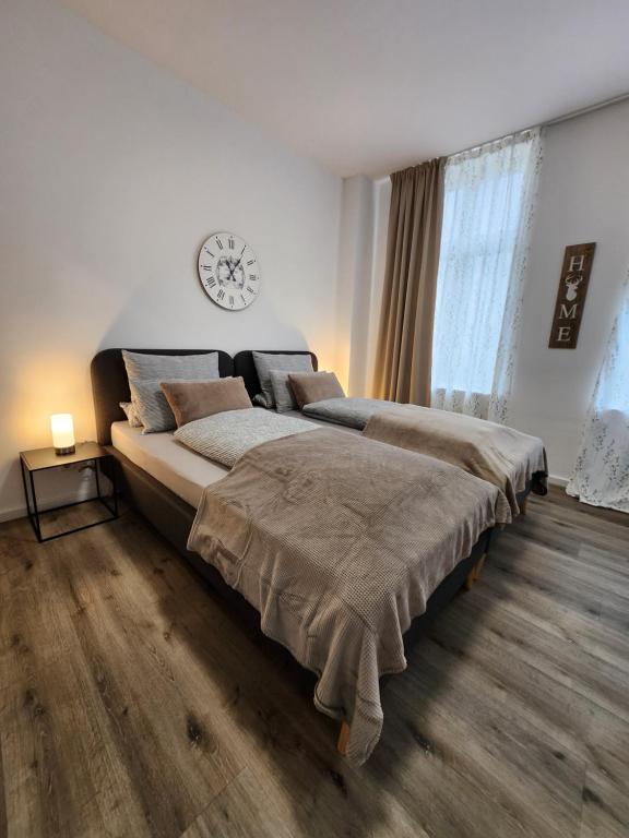 1 dormitorio con 1 cama grande y reloj en la pared en Landhaus Appartement, en Bad Salzuflen