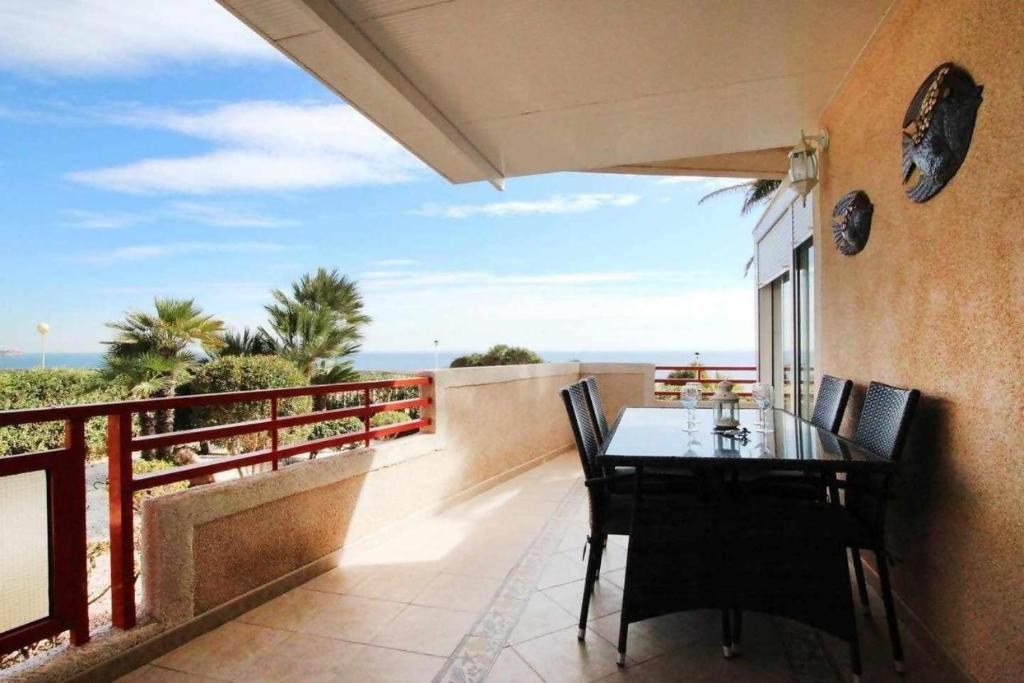 een eettafel op een balkon met uitzicht op de oceaan bij Vistamar apartamento in Orihuela-Costa