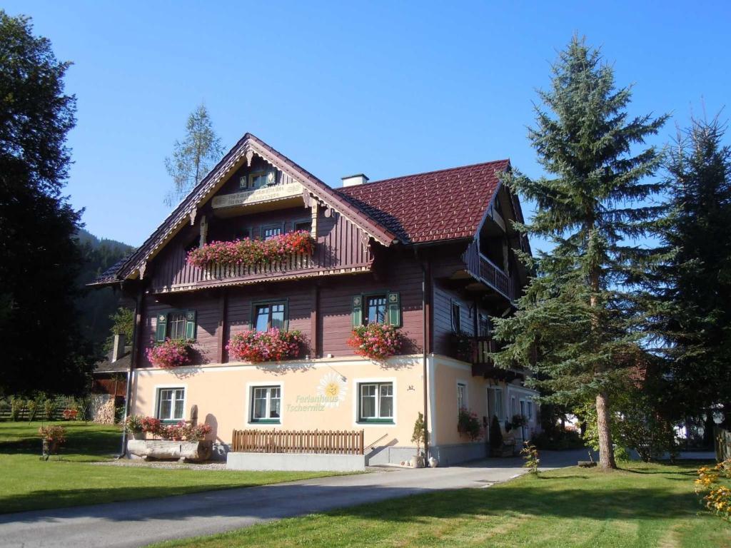 ein großes Haus mit Blumen an den Fenstern in der Unterkunft Ferienhaus Tschernitz in Pruggern