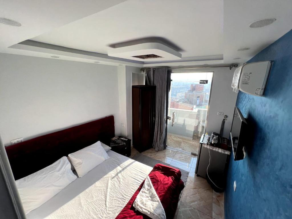 a bedroom with a bed and a large window at pyramids stone Top in Cairo