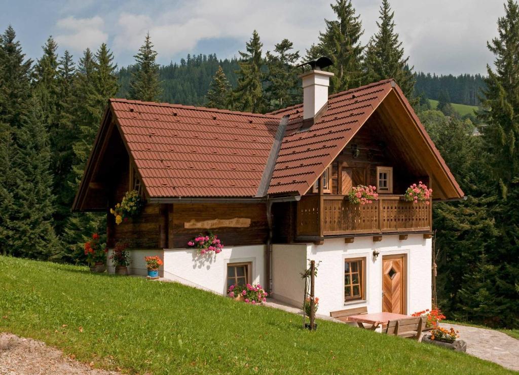 ein kleines Haus mit Balkon auf einem Hügel in der Unterkunft Pircherhof - Urlaub und Erholung im Troadkost'n in Sankt Kathrein am Hauenstein