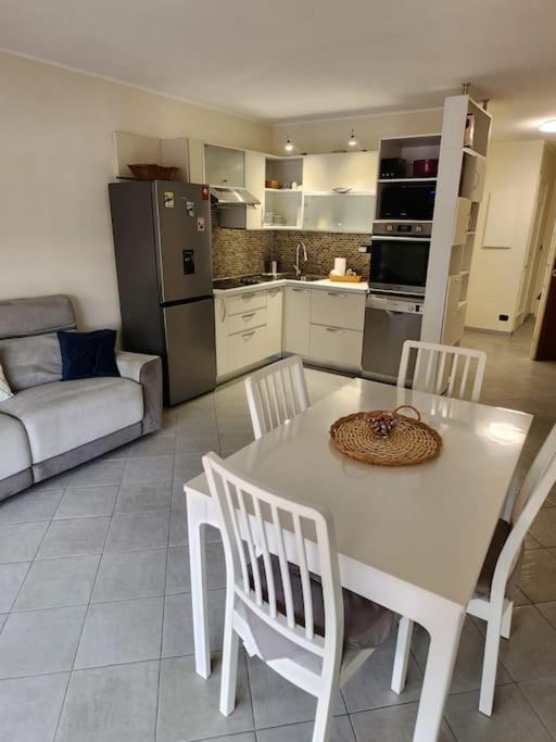 une cuisine avec une table blanche, des chaises et un canapé dans l'établissement Appartement Ambassadeur, à Menton