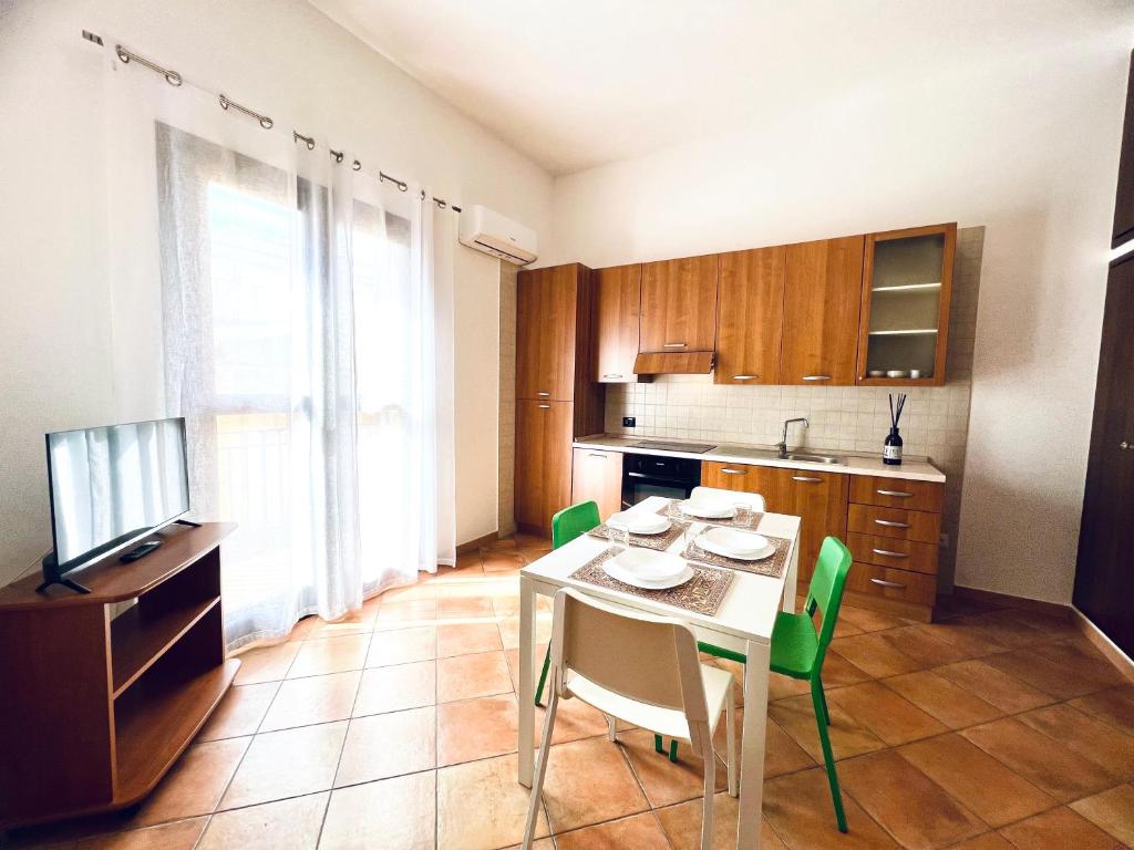 a kitchen with a table and green chairs in a room at Casa Carlotta Apartments in Terrasini