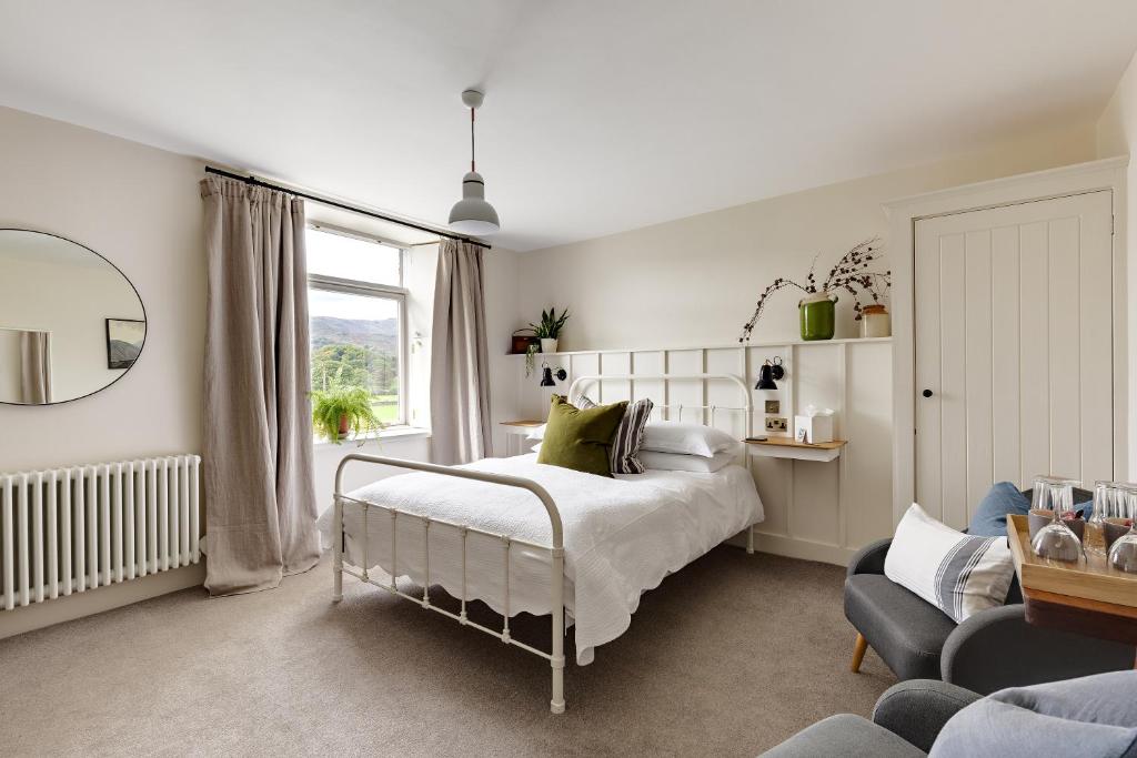 um quarto com uma cama, uma cadeira e uma janela em Chestnut Villa em Grasmere