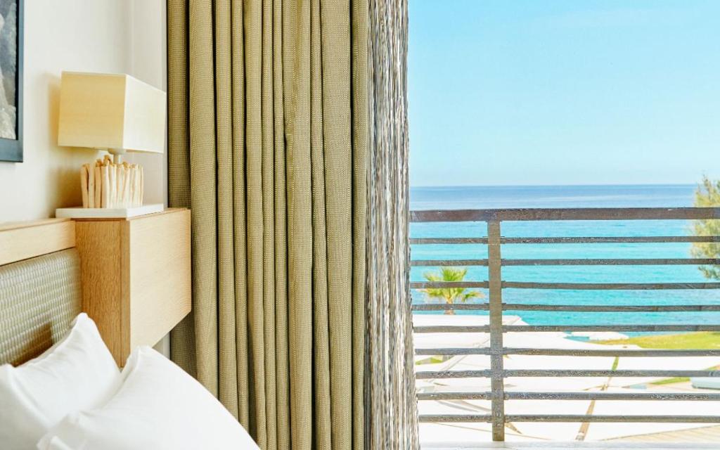 a bedroom with a window with a view of the ocean at Capovaticano Resort Thalasso Spa in Capo Vaticano