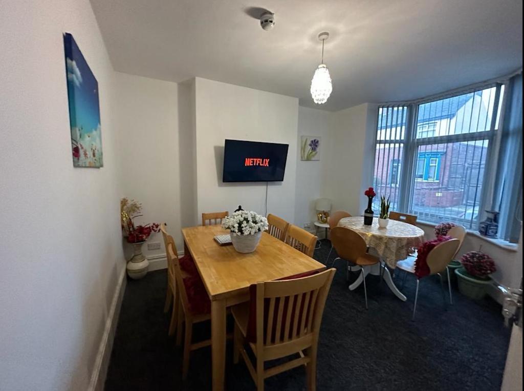 a dining room with a table and a tv at Central Doncaster 5BED 3BATH ParkView Mansion in Doncaster