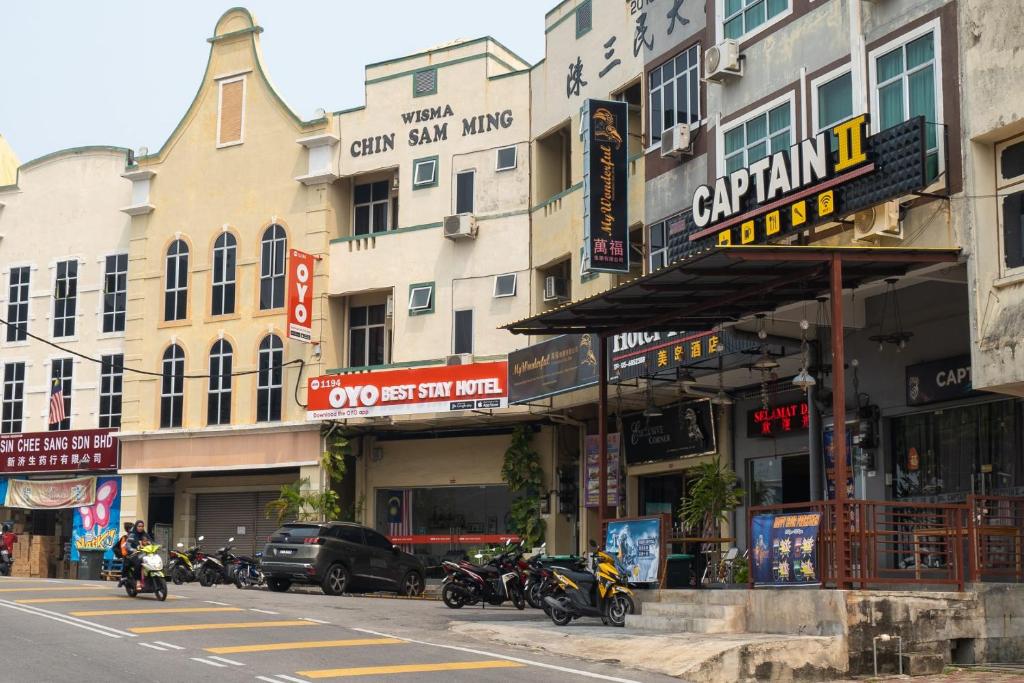 eine Gruppe von Motorrädern, die an der Straßenseite geparkt sind in der Unterkunft OYO 1194 Best Stay Hotel Pangkor in Pulau Pangkor